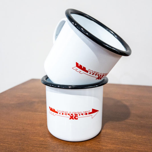 Two white enamel mugs with black rims stacked on a wooden surface, displaying red Wellesley XC logo, perfect for cross country runners or team supporters